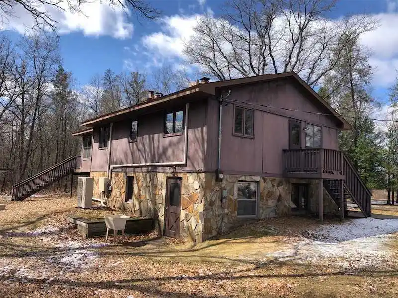 Before photo of a home before new windows and vinyl siding installation